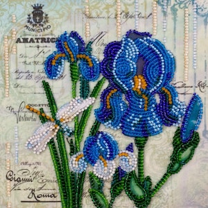 Peut inclure: Une œuvre d'art perlée représentant des fleurs d'iris bleues et une libellule. Les fleurs sont détaillées avec des nuances de perles bleues et jaunes, avec des tiges et des feuilles vertes. Une libellule avec des perles blanches et dorées est positionnée près des fleurs. Le fond a une écriture vintage.