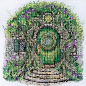 May include: A green door with a round window and a gold door knocker is surrounded by vines and flowers. The door is set into a stone archway and leads to a set of stone steps.