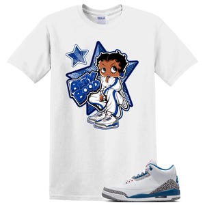 May include: A white short-sleeve t-shirt featuring a graphic of the cartoon character Betty Boop wearing a white and blue tracksuit and sneakers, positioned in front of a large blue star with the text Betty Boop. A white and blue sneaker is below.