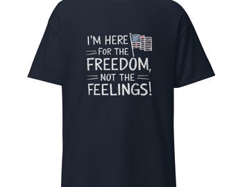 Puede incluir: Camiseta azul marino con un gráfico blanco que dice "Estoy aquí por la libertad, no por los sentimientos!" y un pequeño gráfico de bandera estadounidense.