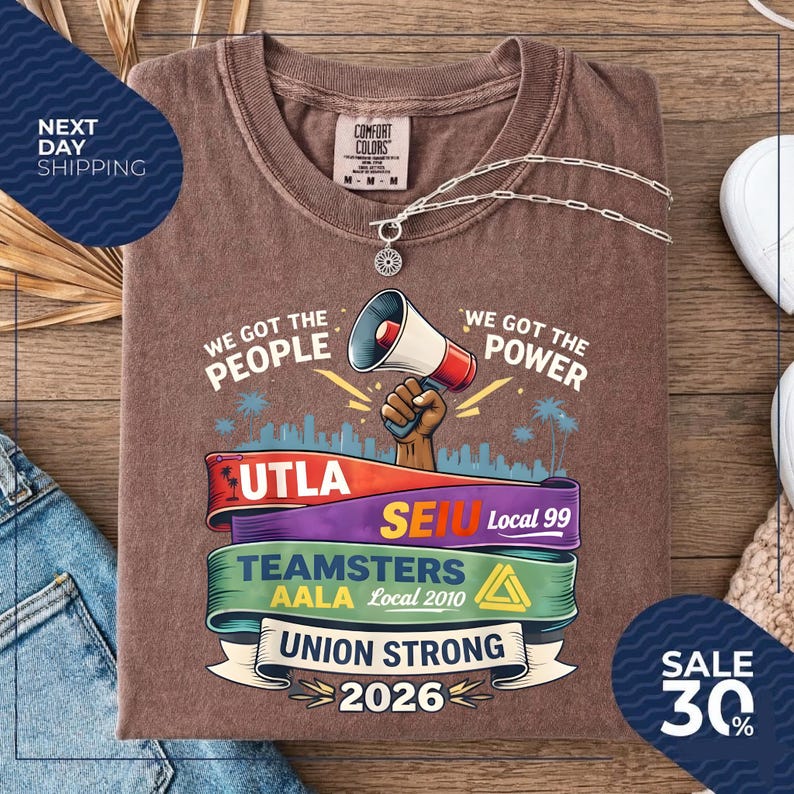 May include: Brown t-shirt with a graphic featuring a megaphone, the words "We Got The People" and "We Got The Power", and union logos. The shirt also has the text "Union Strong 2026".