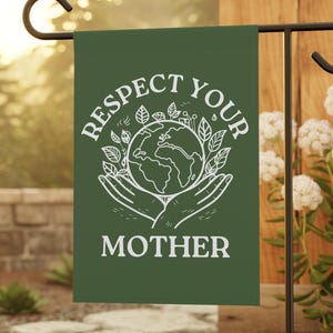 May include: A green garden flag with the words "RESPECT YOUR MOTHER" in white. The design includes a globe encircled by leaves, held by two hands. The flag is displayed on a black metal stand, set in a garden setting.