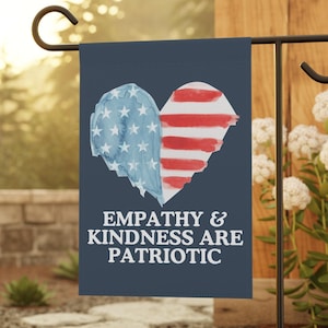 May include: A navy blue garden flag with a heart design split into two halves, one with blue stars and the other with red stripes. The text "EMPATHY & KINDNESS ARE PATRIOTIC" is displayed in white.