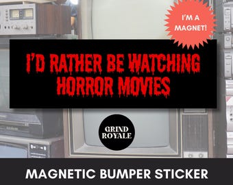 May include: A black and red magnetic bumper sticker with the text "I'd rather be watching horror movies" and the logo "Grind Royale".
