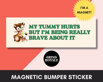Puede incluir: Una pegatina magnética rectangular con fondo crema que presenta un oso pardo de estilo vintage sosteniendo un tarro de miel. El texto dice: MY TUMMY HURTS BUT I'M BEING REALLY BRAVE ABOUT IT. Un gráfico de estrella amarilla dice I'M A MAGNET.