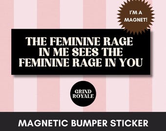 May include: Black magnetic bumper sticker with white text that reads "THE FEMININE RAGE IN ME SEES THE FEMININE RAGE IN YOU." A brown starburst shape says "I'M A MAGNET!" The bottom reads "MAGNETIC BUMPER STICKER" with a "GRIND ROYALE" logo.