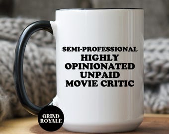 May include: White ceramic mug with a black rim and handle. The mug has black text that reads "Semi-Professional Highly Opinionated Unpaid Movie Critic". The mug has a black sticker on the bottom that reads "Grind Royale".