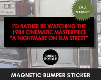 May include: A black magnetic bumper sticker with the text "I'D RATHER BE WATCHING THE 1984 CINEMATIC MASTERPIECE 'A NIGHTMARE ON ELM STREET'". The sticker also features the Grind Royale logo and a green starburst that says "I'M A MAGNET!"