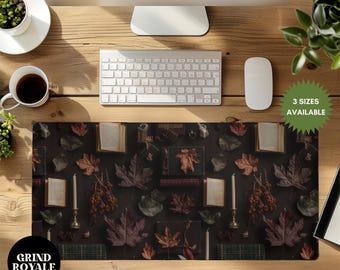 Puede incluir: Una alfombrilla de escritorio marrón oscuro con un diseño de otoño que presenta hojas de otoño, libros y velas. La alfombrilla está rodeada por un monitor de computadora, un teclado, un ratón y una taza de café. El texto "3 SIZES AVAILABLE" es visible en la esquina superior derecha de la imagen.