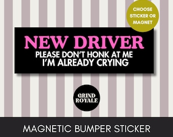 May include: A black magnetic bumper sticker with the text "NEW DRIVER PLEASE DON'T HONK AT ME I'M ALREADY CRYING" in pink and white. The sticker also includes the Grind Royale logo and the words "CHOOSE STICKER OR MAGNET".