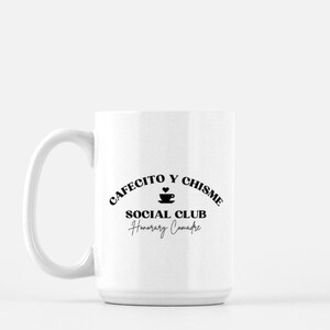 Peut inclure: Une tasse &agrave; caf&eacute; en c&eacute;ramique blanche avec un motif noir qui dit "Cafecito y Chisme Social Club Honorary Comadre".