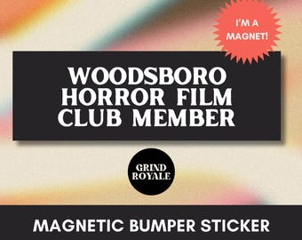 May include: A black magnetic bumper sticker with white text that reads "WOODSBORO HORROR FILM CLUB MEMBER." A red starburst sticker says "I'M A MAGNET!" The bottom of the sticker says "MAGNETIC BUMPER STICKER."