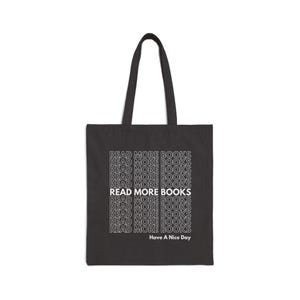 May include: Black tote bag with the text "READ MORE BOOKS" repeated multiple times in white. The text is in a retro font style. The bottom of the bag says "Have A Nice Day".