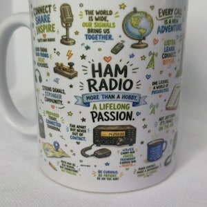 May include: A white ceramic mug featuring colourful illustrations related to amateur radio, including a globe, microphone, and radio equipment. The text reads: HAM RADIO MORE THAN A HOBBY, A LIFELONG PASSION, along with various phrases about connection.