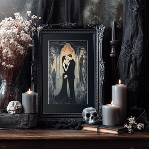 May include: A black framed art print showing a couple embracing in a gothic scene. The image is surrounded by candles, a skull, and dried flowers, creating a dark, romantic atmosphere. The color scheme is mainly black, grey, and cream.