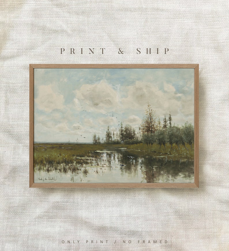 May include: A framed print of a landscape painting depicting a river flowing through a field with trees and a cloudy sky. The painting is in a light brown frame.