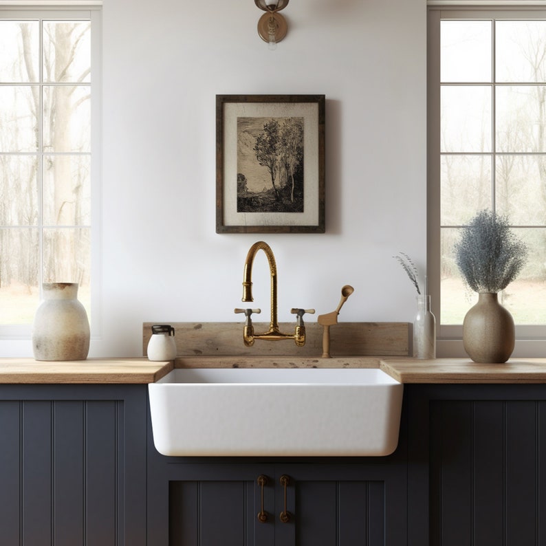 May include: A white farmhouse sink with a gold faucet and a wooden countertop. The sink is in a kitchen with dark blue cabinets and a window behind it.
