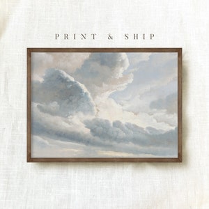 May include: A framed print of a painting depicting a cloudy sky in shades of blue and gray. The clouds are fluffy and appear to be moving across the sky. The print is in a simple brown frame.