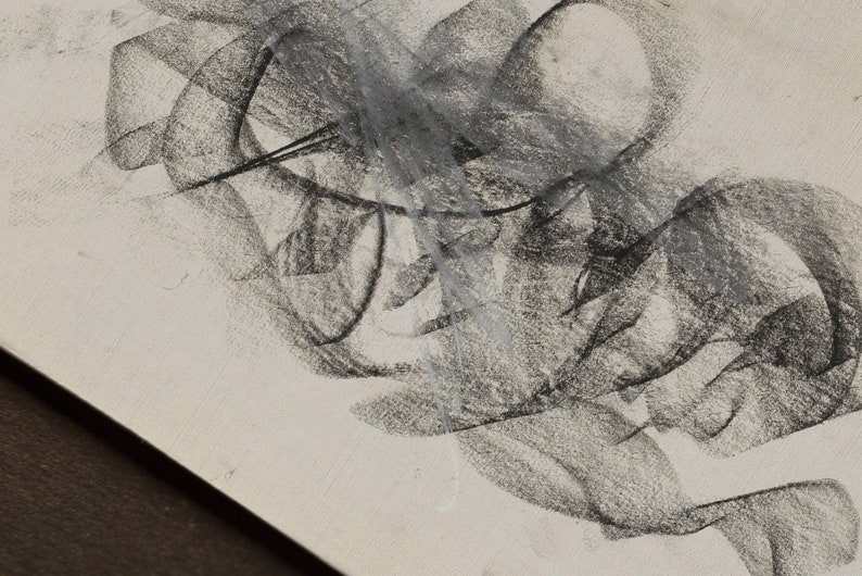 Op de afbeelding: Abstracte houtskooltekening op een witte achtergrond. De tekening bestaat uit overlappende lijnen en vormen, waardoor een gevoel van beweging en diepte ontstaat.