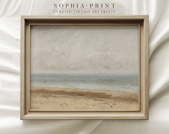 May include: A framed vintage seascape painting with a light blue ocean and a sandy beach in the foreground. The sky is a soft gray with white clouds. The frame is a light brown wood.
