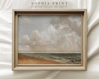 May include: A framed vintage art print of a seascape. The artwork depicts a cloudy sky over a turbulent ocean, with a sandy beach in the foreground. The frame is light-colored wood. The text "SOPHIA PRINT" and "CURATED VINTAGE ART PRINTS" are printed at the top and bottom.