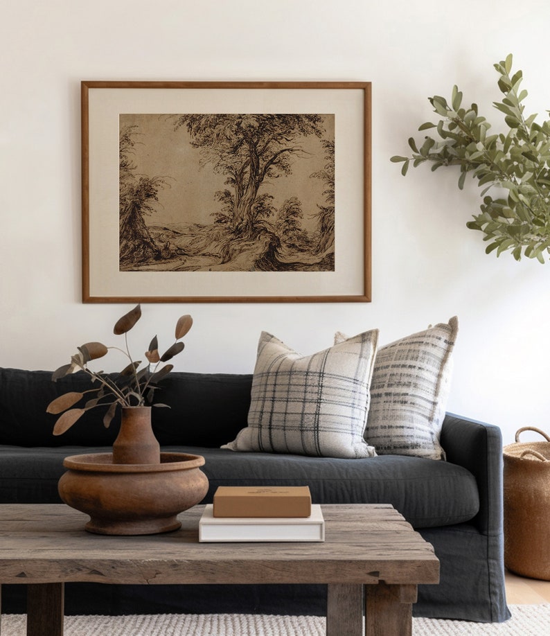 K&ouml;nnte beinhalten: Ein dunkelgraues Sofa mit zwei Kissen, eines mit einem schwarz-wei&szlig; karierten Muster und das andere mit einem grau-wei&szlig; gestreiften Muster. Ein Holz-Couchtisch mit einer braunen Holzkiste und einem wei&szlig;en Buch darauf. Eine Vase mit getrockneten Zweigen steht auf dem Tisch. Ein gerahmtes Schwarzwei&szlig;-Zeichnung einer Landschaft mit B&auml;umen h&auml;ngt an der Wand hinter dem Sofa.