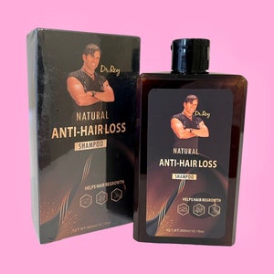 Könnte beinhalten: Eine schwarze und goldene Flasche Dr. Rey Natural Anti-Hair Loss Shampoo. Die Flasche ist mit dem Produktnamen und einem Bild eines Mannes beschriftet. Die Flasche enthält 300 ml.