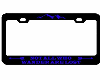 May include: Black metal license plate frame with a blue mountain silhouette and the text "Not all who wander are lost" with blue arrows on either side.