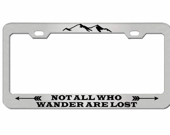 May include: Silver license plate frame with a black mountain silhouette and the text "NOT ALL WHO WANDER ARE LOST" with arrows on either side.