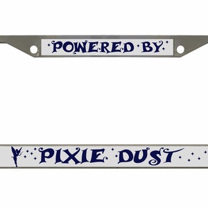 May include: A silver license plate frame with a white background and blue text. The top of the frame says "Powered By" and the bottom says "Pixie Dust" with a fairy silhouette.