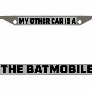 May include: A silver metal license plate frame with the text "MY OTHER CAR IS A THE BATMOBILE" printed in black on a white background.