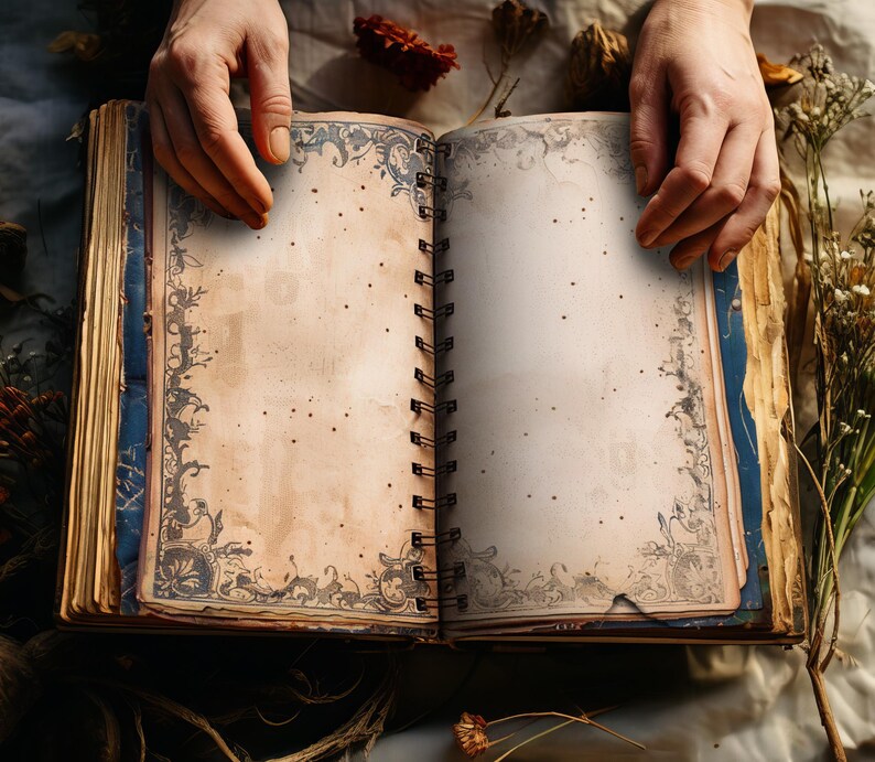 May include: An open journal with a spiral binding, featuring aged cream-coloured pages and dark grey decorative borders. The book is held open, revealing the blank pages, suggesting it's for writing or drawing. The style is reminiscent of an antique book.