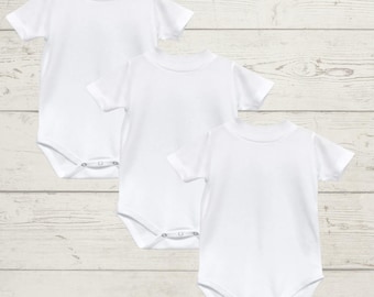 Könnte beinhalten: Drei weiße Baby-Bodys mit kurzen Ärmeln und Druckknöpfen.