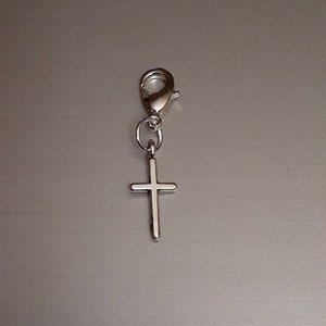 May include: Silver charm with a cross pendant and a lobster clasp.
