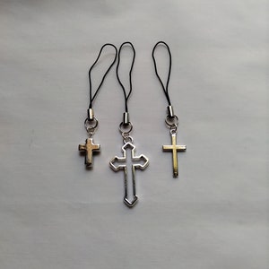 May include: Three silver cross charms with black string phone charms.