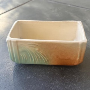 Pode incluir: Um vaso retangular de cerâmica com um esmalte castanho claro e um design de esmalte verde. O vaso tem um interior liso e sem esmalte.