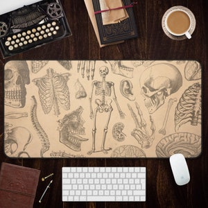 May include: A beige mouse pad with a vintage anatomical illustration of a skeleton, skull, and other body parts. The design is in black and white.
