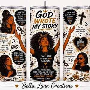 May include: A cylindrical tumbler featuring a white background with gold and black illustrations of a person with curly hair, religious text including 'God Wrote My Story', 'I Will Tell Of What God Has Done', and 'I Am Covered By Grace And Favor'.