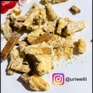 May include: A close-up of a pile of crunchy, golden brown, sugar-coated snacks. The snacks are scattered on a white surface. The Instagram handle @uriwelli is visible in the lower right corner of the image.