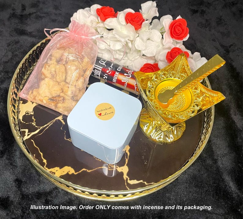 May include: A black and gold tray with a white box, a bag of nuts, and a gold incense burner with a spoon. The tray has a marble pattern. The box has a sticker that says "Handmade with Love".