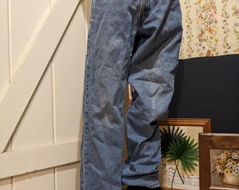 May include: A pair of light blue denim jeans with a classic straight leg fit. The jeans have a faded look and are made of a soft, comfortable cotton blend.