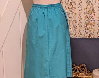 May include: A turquoise blue skirt with an elastic waistband. The skirt is knee-length and has a simple, classic design.