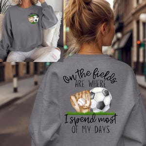 May include: Gray sweatshirt with a graphic of a baseball glove and soccer ball with the text "On the fields are where I spend most of my days".