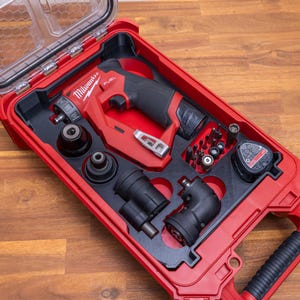 May include: A red Milwaukee Fuel cordless drill system housed in a red plastic carrying case with a clear lid. The set includes a drill body, multiple interchangeable chuck attachments, a battery pack, and an assortment of small metal drill bits.