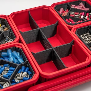 May include: A red plastic storage organizer bin featuring black dividers that create six distinct compartments. The central bin is empty, while surrounding bins contain various metal screws and blue or red electrical wire connectors.