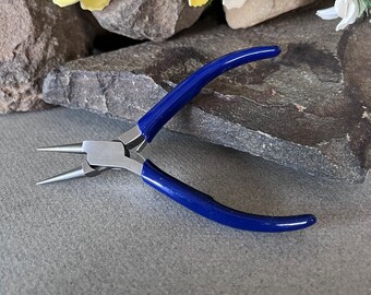 May include: Blue handled jewelry pliers with a silver metal body and pointed tips.