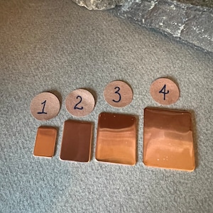 May include: Four copper sheets of varying sizes, labeled 1 through 4. The sheets are arranged in a row from smallest to largest.