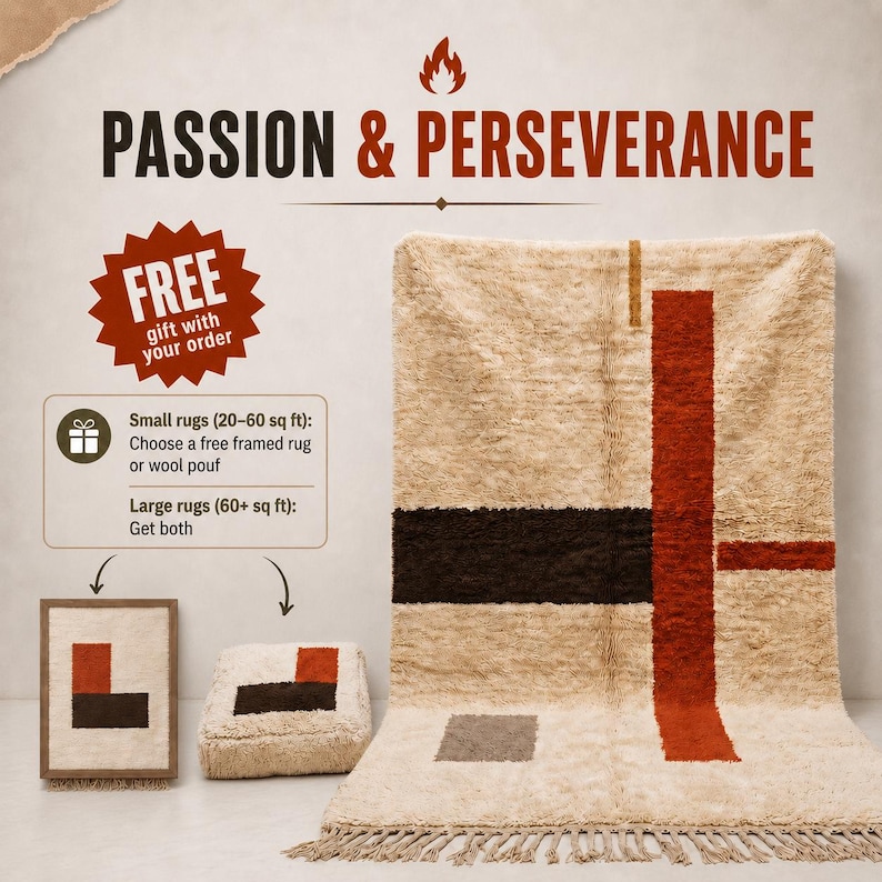 May include: A large, cream-colored, shaggy rug with a geometric pattern of dark brown and rust-orange stripes and a small gray rectangle. The rug features a fringed bottom edge. A matching framed rug and a square wool pouf are displayed nearby.