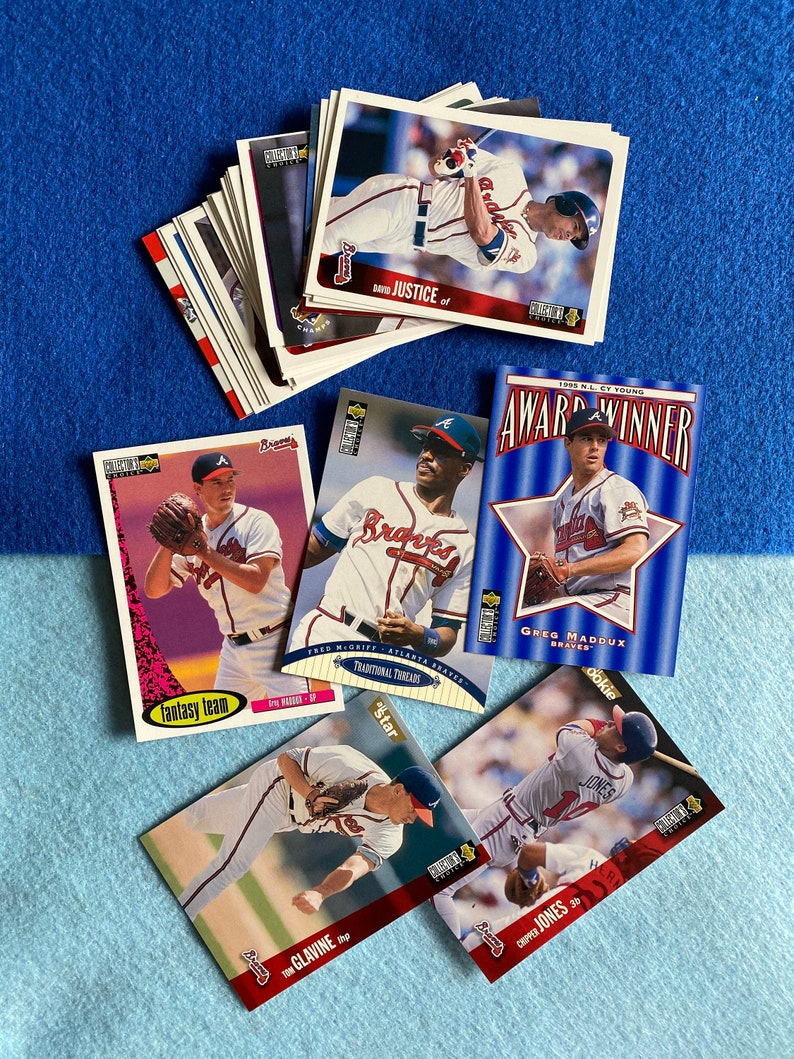 May include: A collection of baseball trading cards featuring Atlanta Braves players. The cards are from the 1995 season and feature players like Greg Maddux, David Justice, and Chipper Jones. The cards are in good condition and would be a great addition to any baseball card collection.