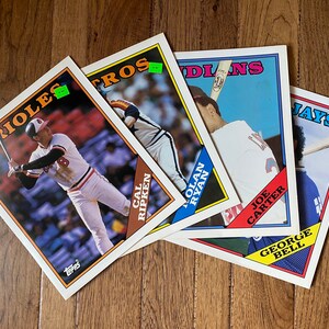 May include: Four baseball cards featuring players from the Orioles, Astros, Indians, and Jays. The cards are all in good condition and have a vintage look.